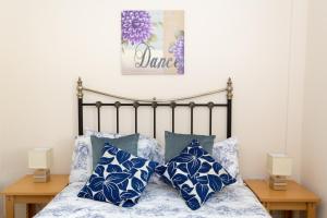 a bedroom with a bed with blue and white pillows at Merlin Cottages in Llandovery