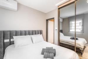 ein Schlafzimmer mit einem großen weißen Bett und einem Spiegel in der Unterkunft Next the Old City - 5 stars apartment - David village in Jerusalem