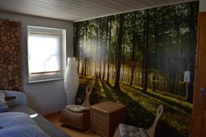 um quarto com um mural de floresta na parede em Zimmer Bärbel em Förbau