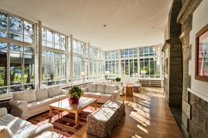 a large living room with a lot of windows at Maloja Palace Residence Engadin-St Moritz CO2-Neutral in Maloja