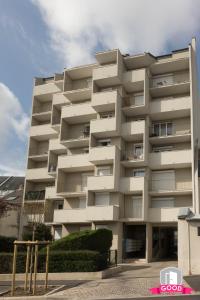 een hoog wit gebouw met struiken ervoor bij Le Duplex Ensoleillé du Parc * Parking * Balcon * in Orléans