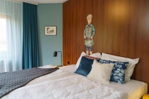 Tante ALMA's Bonner Hotel في بون: غرفة نوم بسرير مع لوحة على الحائط