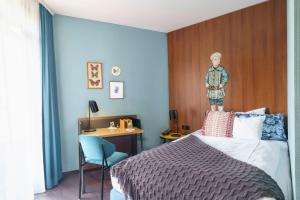 een slaapkamer met een bed met een houten hoofdeinde en een bureau bij Tante ALMA's Bonner Hotel in Bonn