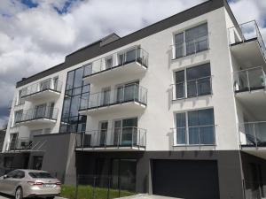 an apartment building with a car parked in front of it at Apartament Ambra Baltica- 365PAM in Gąski