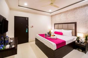 a bedroom with a large bed with a pink blanket at Hotel Signature Airport Zone Shamshabad Hyderabad in Hyderabad