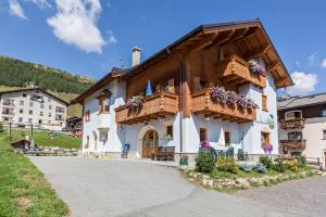 a building with flowers on the balconies of it at Zenith - Casa Azzurra Mansarda in Livigno