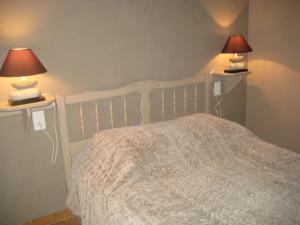 een slaapkamer met een wit bed met 2 lampen erop bij Gite des Ocres in Villars