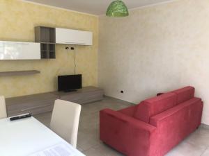 a living room with a red couch and a tv at Villa Giantonia in Minturno