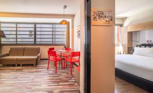 a hotel room with a bed and a table and chairs at Ben Yehuda Apartments in Tel Aviv