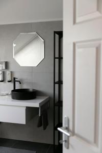 a bathroom with a sink and a mirror at KRACHER Ferienhaus No 2 in Illmitz