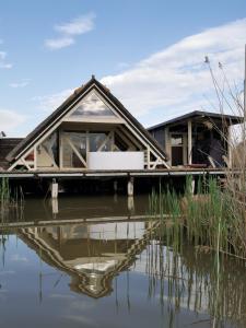 a house on a dock next to a body of water at Pfahlbau Rust/Neusiedlersee Sunset II in Rust