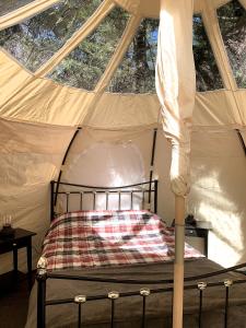 Rúm í herbergi á Glamping at Camping La Source
