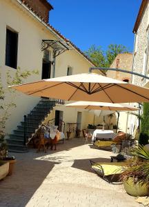 un grand parasol devant un bâtiment dans l'établissement La parenthèse Thuir piscine privée et chauffée, à Thuir