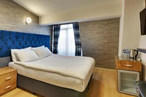 a bedroom with a large bed with a blue headboard at Grande Stella Hotel in Eskisehir