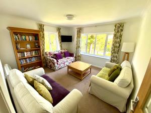 a living room with two white couches and a table at Haytor Court, Haytor, Dartmoor in Haytor