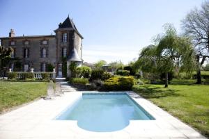 a large swimming pool in front of a house at Les Lauriers in Peyrat-de-Bellac