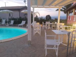 a patio with a table and chairs next to a pool at Borgo di Santa Barbara in Santa Domenica