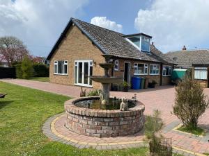 a house with a fountain in front of a house at Thorncroft B&B - Adults only in Flamborough