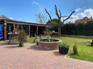 a brick patio with a fountain in a yard at Thorncroft B&B - Adults only in Flamborough +11 photos