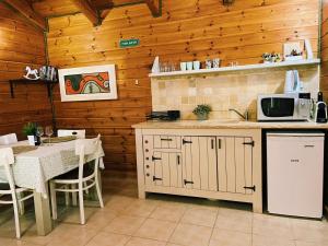 eine Küche mit Tisch und Arbeitsfläche mit Mikrowelle in der Unterkunft Julie's Cabins in Neot Golan