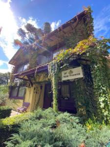 a building covered in ivy with a sign on it at Petit Hotel Provence Gramado in Gramado