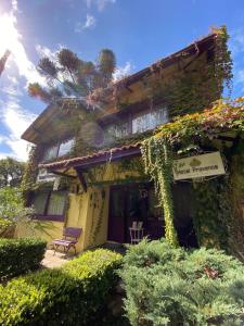 dom z bluszczem rosnącym po jego stronie w obiekcie Petit Hotel Provence Gramado w mieście Gramado