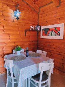 una mesa y sillas en una habitación con paredes de madera en Julie's Cabins en Neot Golan