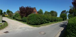 an empty road with a house in the background at Hook in Midlum