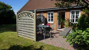 a backyard with a wooden gate and a table in the yard at Ferienhaus Ellen, EG Whg in Utersum