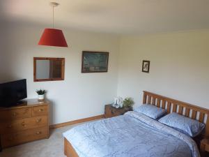 a bedroom with a bed and a television and a dresser at Thorncroft B&B - Adults only in Flamborough +9 photos