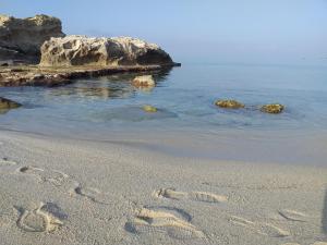 a pair of footprints in the sand on a beach at Borgo di Santa Barbara in Santa Domenica