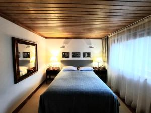 - une chambre avec un lit, un miroir et une fenêtre dans l'établissement Casa do Penedo - Quinta de Fundevilla, à Gerês