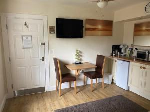 a kitchen with a table and two chairs and a kitchen with a refrigerator at Crossways Tavern in Exeter