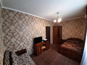アドレルにあるGuest house Agava Chkalova 15Aのベッドルーム1室(ベッド1台、デスク、テレビ付)