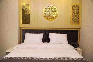 1 cama con sábanas blancas y cabecero negro en The Grand Tower Hotel en Estambul