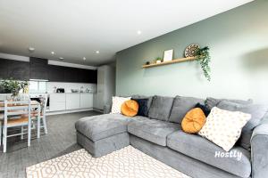 a living room with a gray couch and a kitchen at Vanburgh Court Apartments in Slough