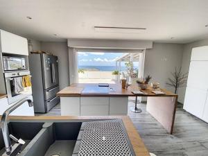 une cuisine avec une table et une vue sur l'océan dans l'établissement Villa La Guapa, sea view, private pool, 5 min from the beach, à Oyster Pond