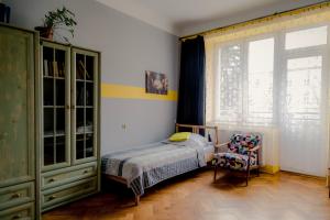 um quarto com uma cama, uma cadeira e uma janela em Centrum 51 em Lublin