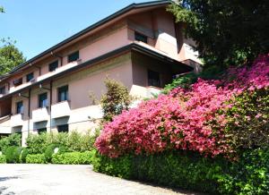 un edificio con fiori rosa di fronte di Hotel Canturio a Cantù