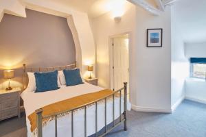 een slaapkamer met een groot bed met blauwe kussens bij Host & Stay - Dove Grey, 25 West End in Kirkbymoorside