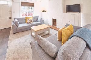 een woonkamer met een bank en een tafel bij Host & Stay - Dove Grey, 25 West End in Kirkbymoorside