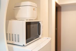 a white microwave sitting on top of a white shelf at OSAKA SUNSHINE TOWER82 in Osaka