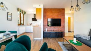 Televízia a/alebo spoločenská miestnosť v ubytovaní Apartamenty EverySky Nad Łomnicą 15-15A