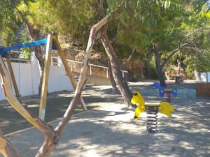 plac zabaw z żółtą zabawką na huśtawce w obiekcie Anassa Cycladic Village w mieście Galissas
