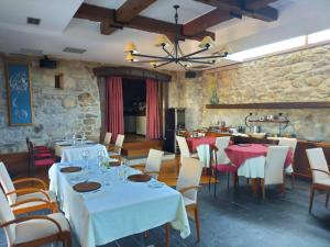 un restaurant avec des tables et des chaises et un mur en pierre dans l'établissement Las Horas Perdidas, à Moscán