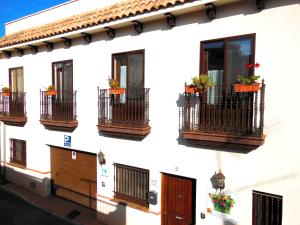 biały budynek z balkonami i kwiatami w obiekcie Casa Rural Jardín del Desierto w mieście Tabernas