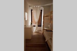 a room with bunk beds and a hallway with a window at Appartamento Sunrise - Centro Storico N2 in Riva del Garda +25 photos