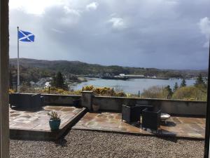 a view of a river from a balcony with a flag at Suil Na Mara Studio in Lochinver