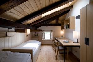 a bedroom with a bed and a desk and a table at Hotel Kolping Hallein in Hallein