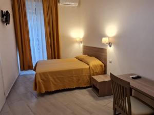 a hotel room with a bed and a desk at Albergo Enrica in Rome